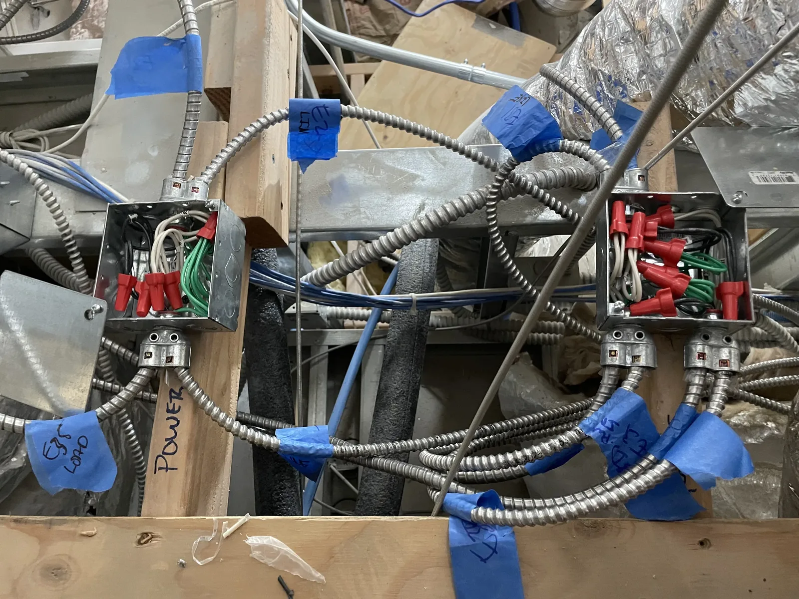 Labeled junction boxes and flexible conduit runs during a commercial rough-in